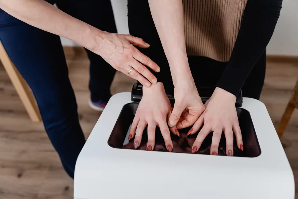 Handmessung an Patient an Terminalpunktdiagnosen Maschine, Therapeut hilft bei Handplatzierung